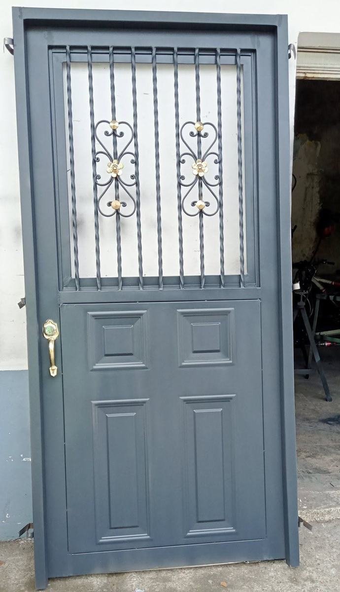 Puerta metálica con reja forjada y rosetas decorativas